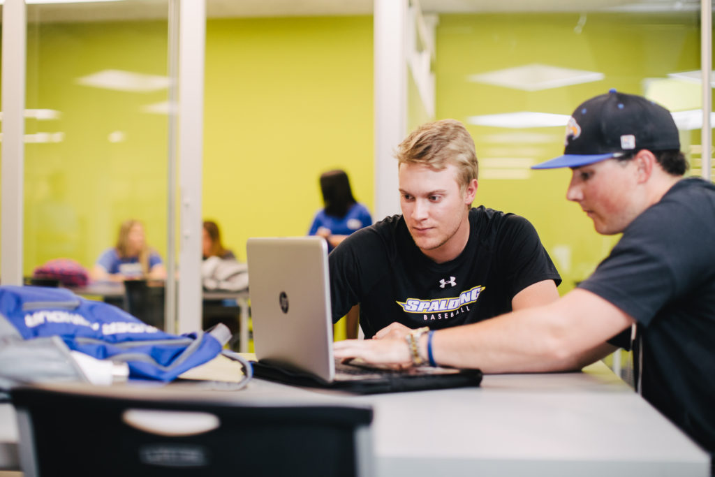 Spalding baseball players studying in the library