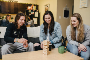 Spalding Suites Living Room with students playing Jenga
