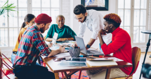 Group of people gathered around table working.