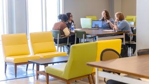 four students sitting at table talking
