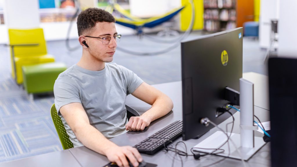 male student sitting at computer