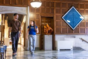 Two students walking inside a lobby of a building at Spalding